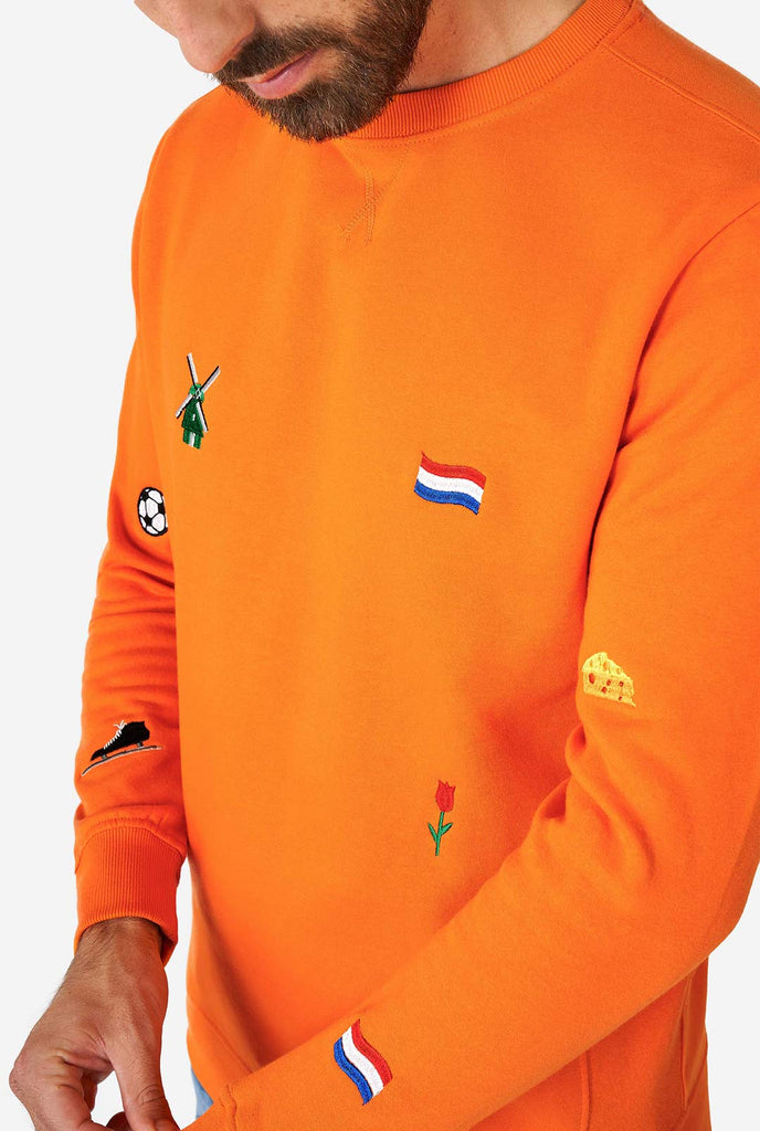 Man wearing orange sweater with Dutch icons
