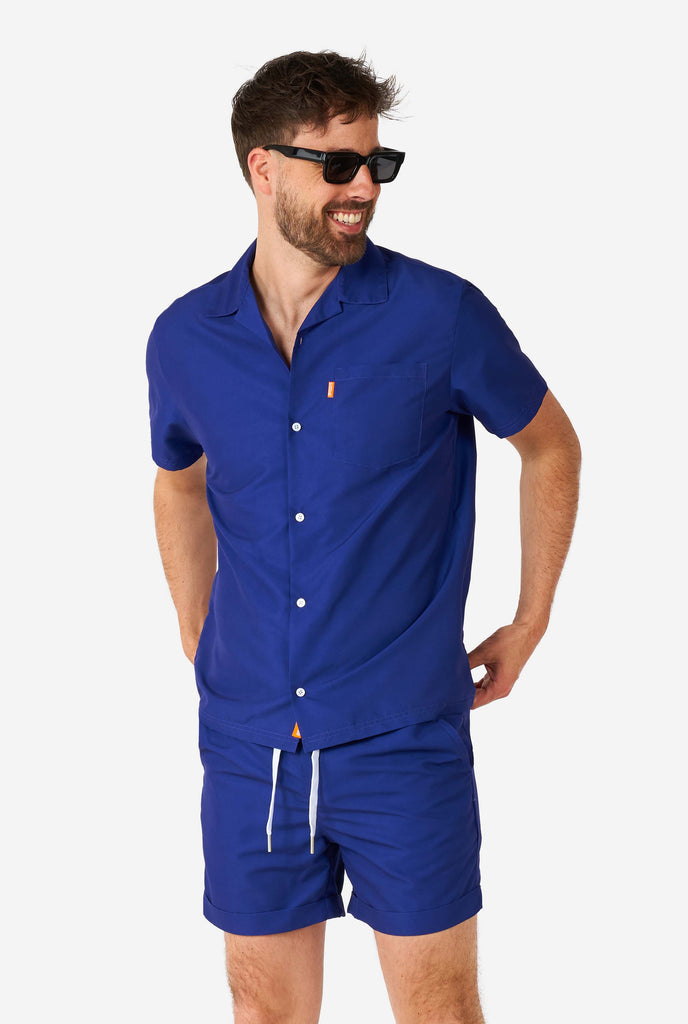 Man wearing blue summer set consisting of shirt and shorts