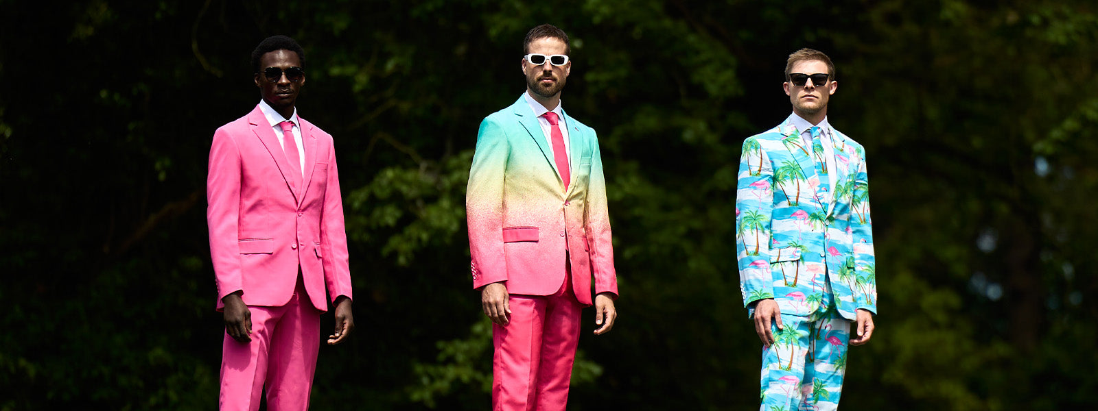 Website banner product page, 3 men wearing opposuits suits. The man one the left is wearing a Mr. Pink suit, the man in the middle is wearing a Funky Fade suit and the man on the right is wearing a Flaminguy suit.