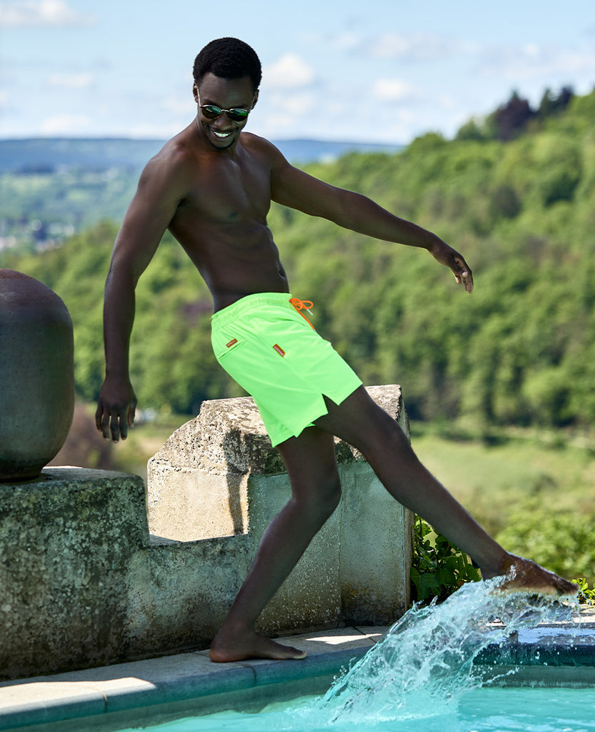 Man wearing neon swimshorts