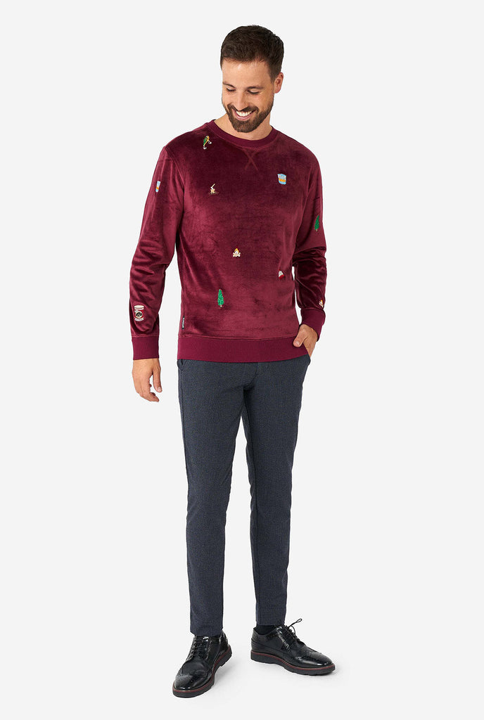 Man wearing velver burgundy red Christmas sweater with Christmas icons