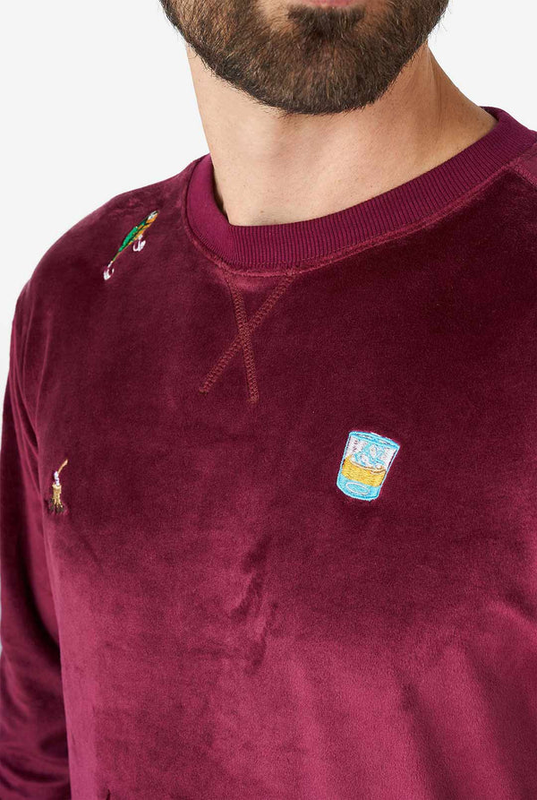 Man wearing velver burgundy red Christmas sweater with Christmas icons