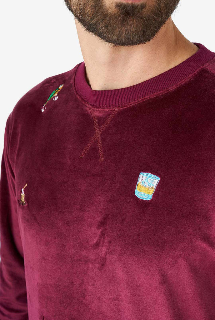 Man wearing velver burgundy red Christmas sweater with Christmas icons