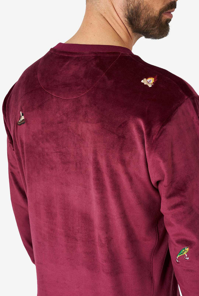 Man wearing velver burgundy red Christmas sweater with Christmas icons