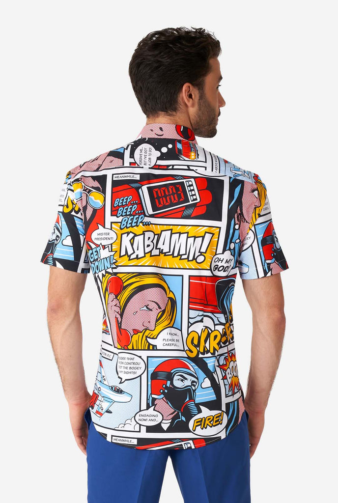 Man wearing summer shirt with Comic book print and blue shorts, view from the back