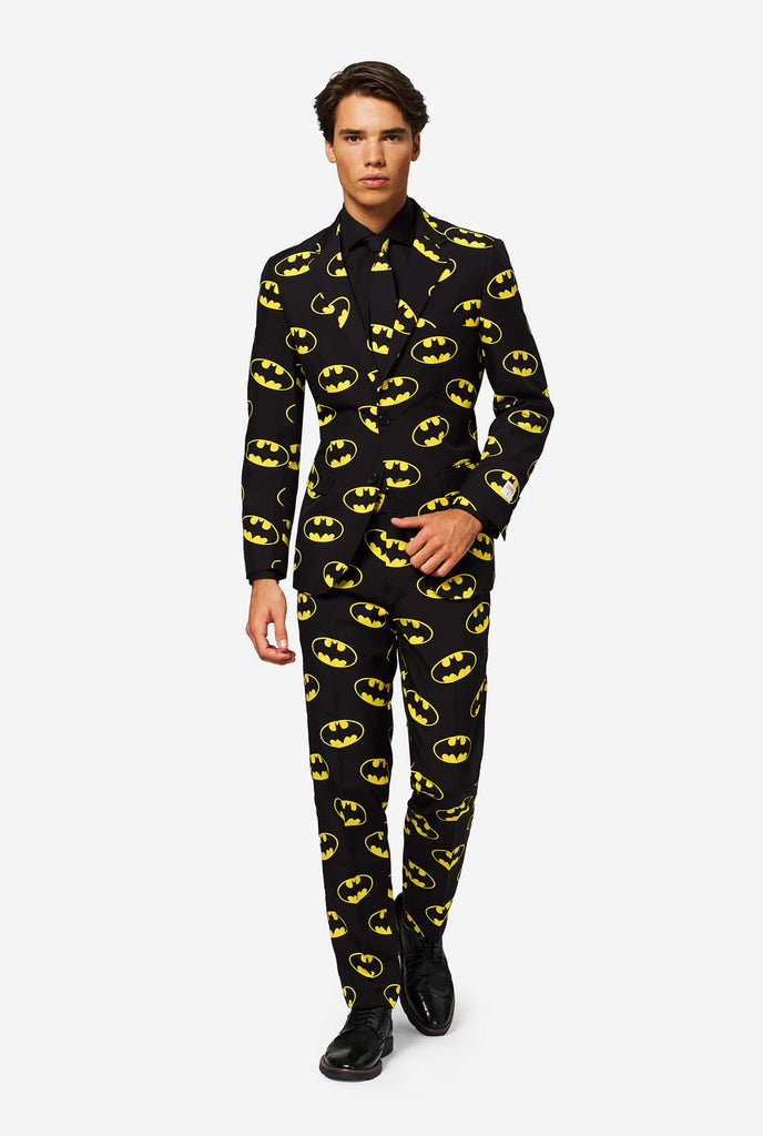 Man wearing Black suit with Yellow Batman logos.