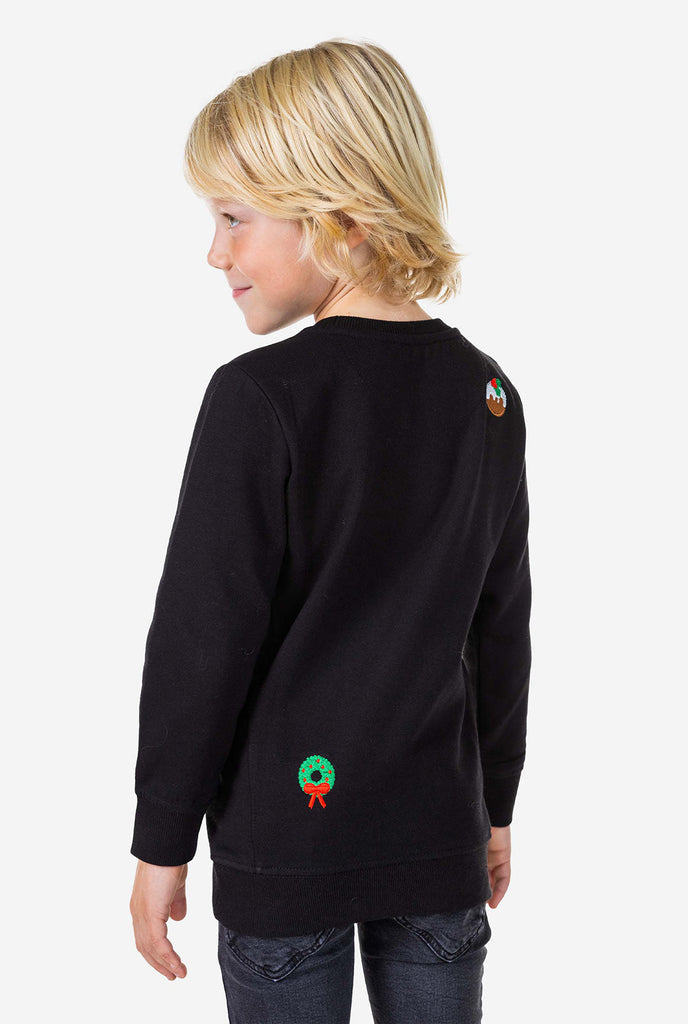 Kid wearing black Christmas sweater with Christmas icons