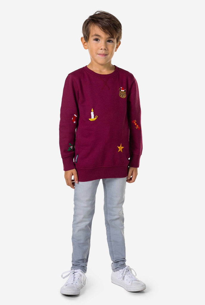 Kid wearing burgundy red Christmas sweater with Christmas icons