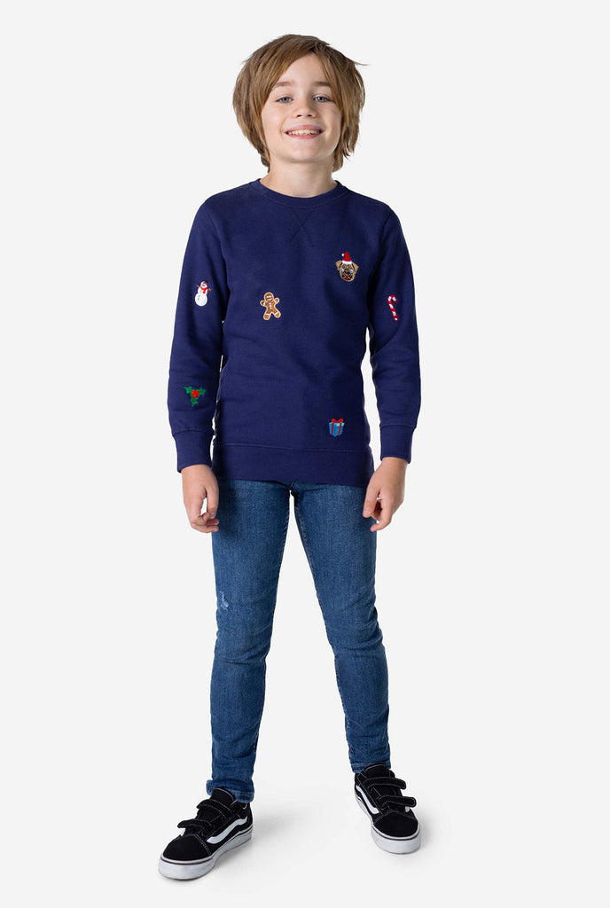 Kid wearing blue Christmas sweater with Christmas icons