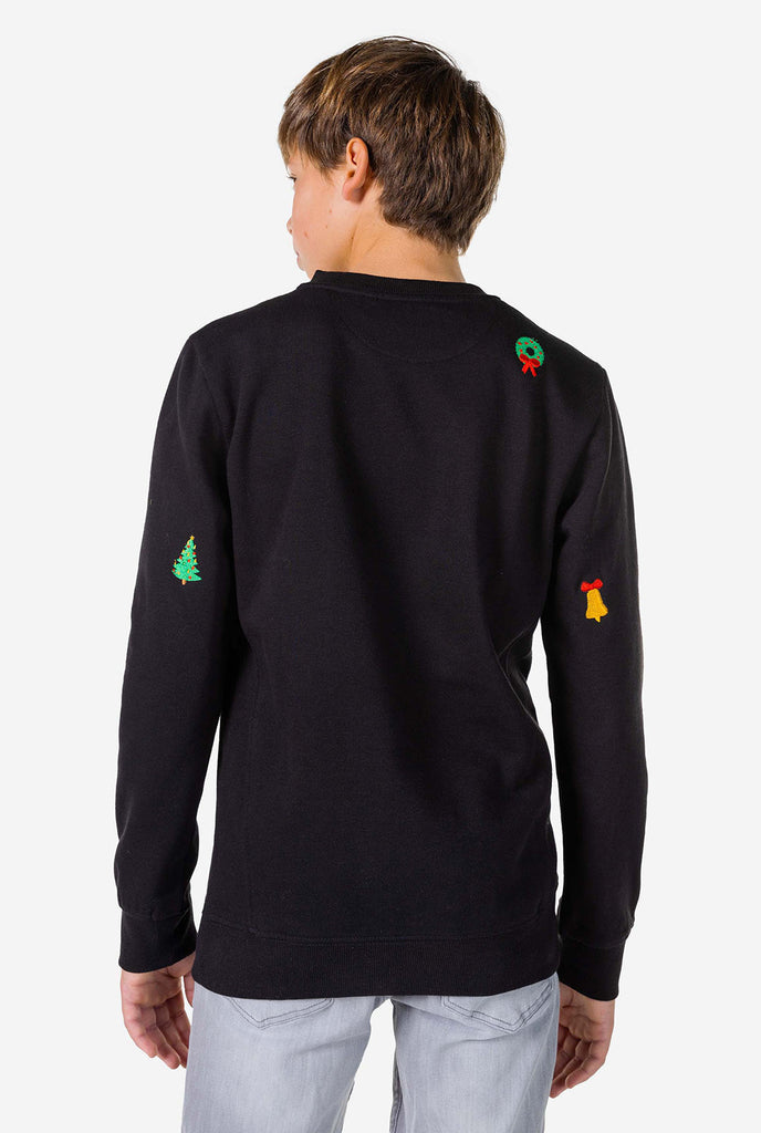 Teen wearing black Christmas sweater with Christmas icons