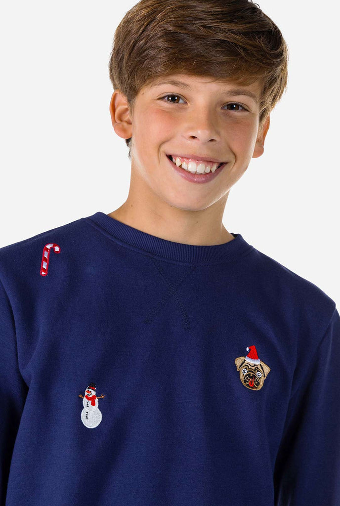 Kid wearing blue Christmas sweater with Christmas icons