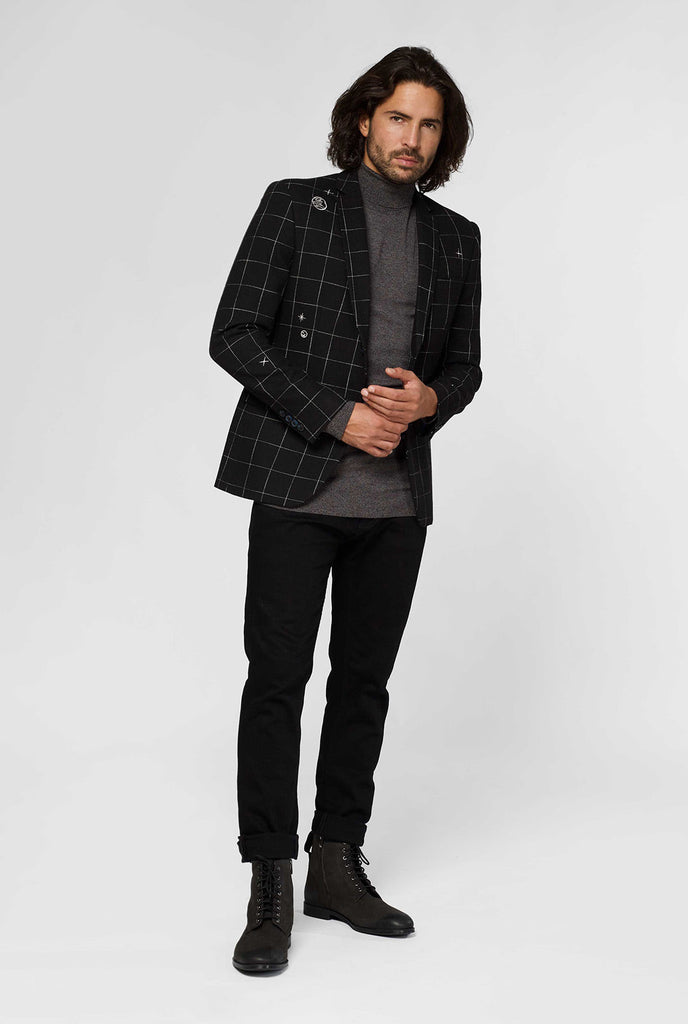 Black casual blazer with white grid pattern worn by man sitting on stool