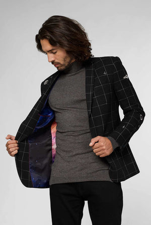 Black casual blazer with white grid pattern worn by man sitting on stool