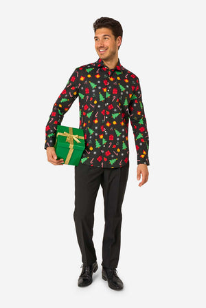 Man wearing a black festive patterned shirt with colorful Christmas designs on a white background. Holding a present, full body image