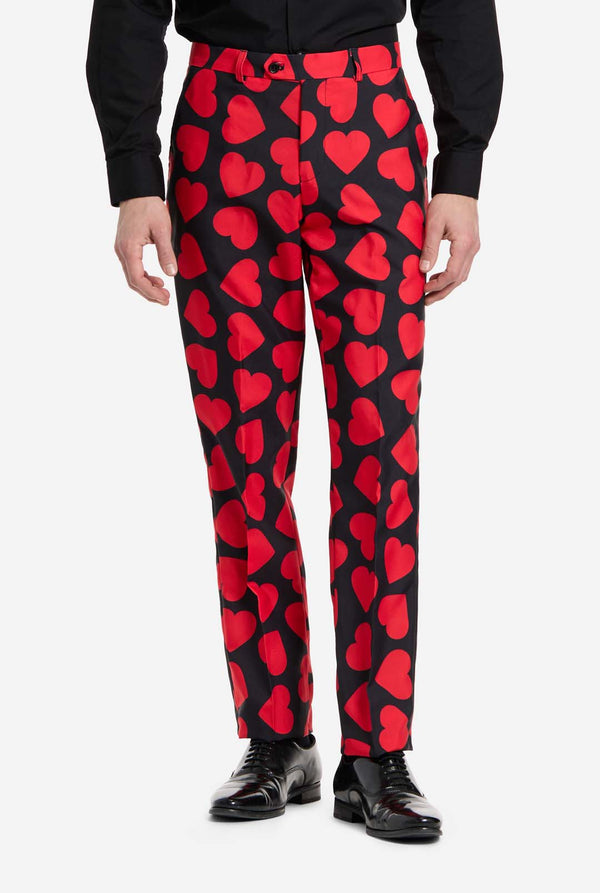 Red heart-patterned pants worn by a person on a white background