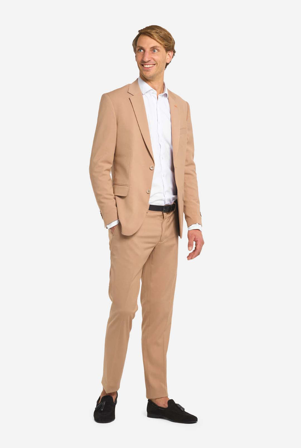 Image with light grey background and man wearing Dark Sand men’s suit and white shirt. Suits consists of blazer and pants. Man looking to the side.