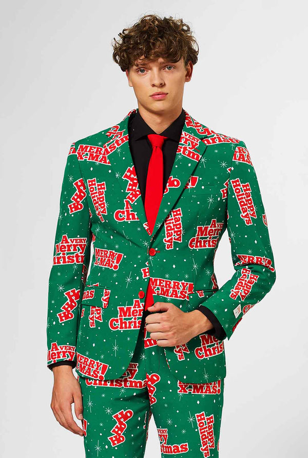 Man wearing green Christmas suit with red Christmas phrases