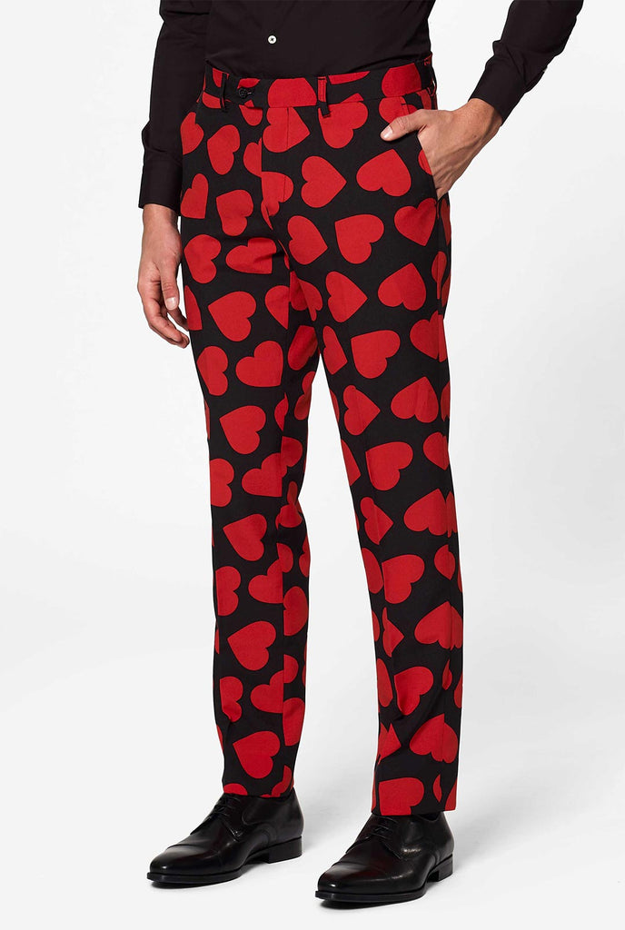 Man wearing black suit with red hearts print