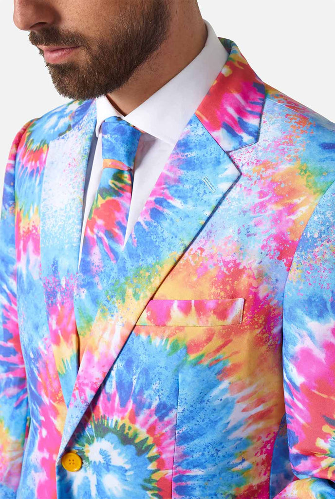 Man wearing pride men's suit with colorful tie dye rainbow print 
