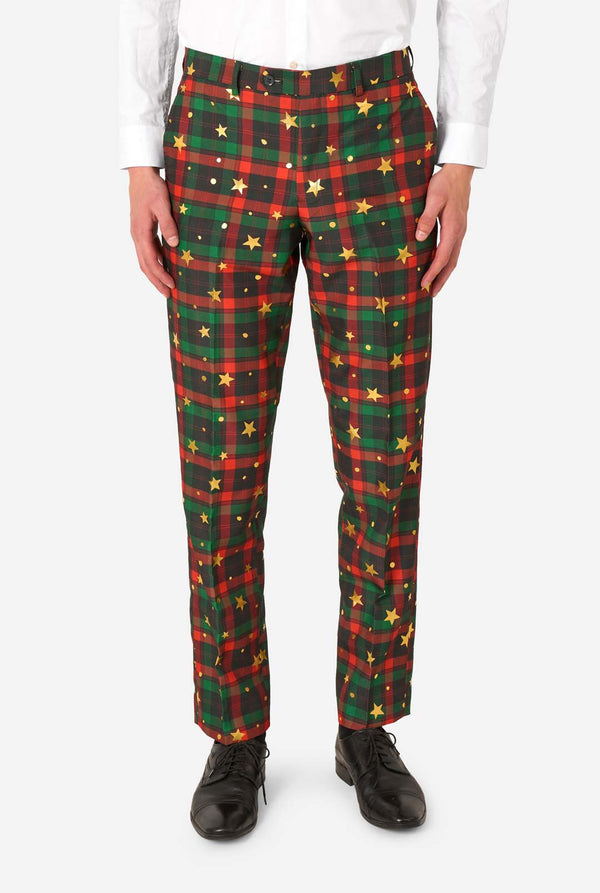 Close-up of tartan plaid suit trousers with gold star and dot accents, paired with black dress shoes