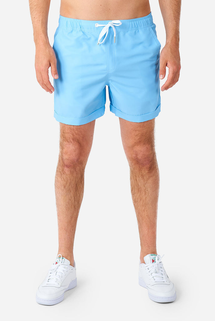 Man wearing light blue summer set, consisting of shirt and shorts. Zoom in on shorts