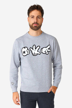 Man wearing grey sweater with chenille rock, paper, scissors embroidery