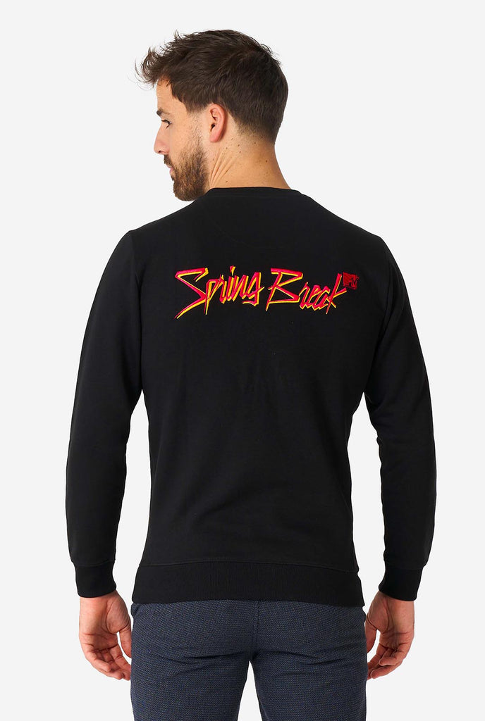 Man wearing black sweater with MTV embroidery.