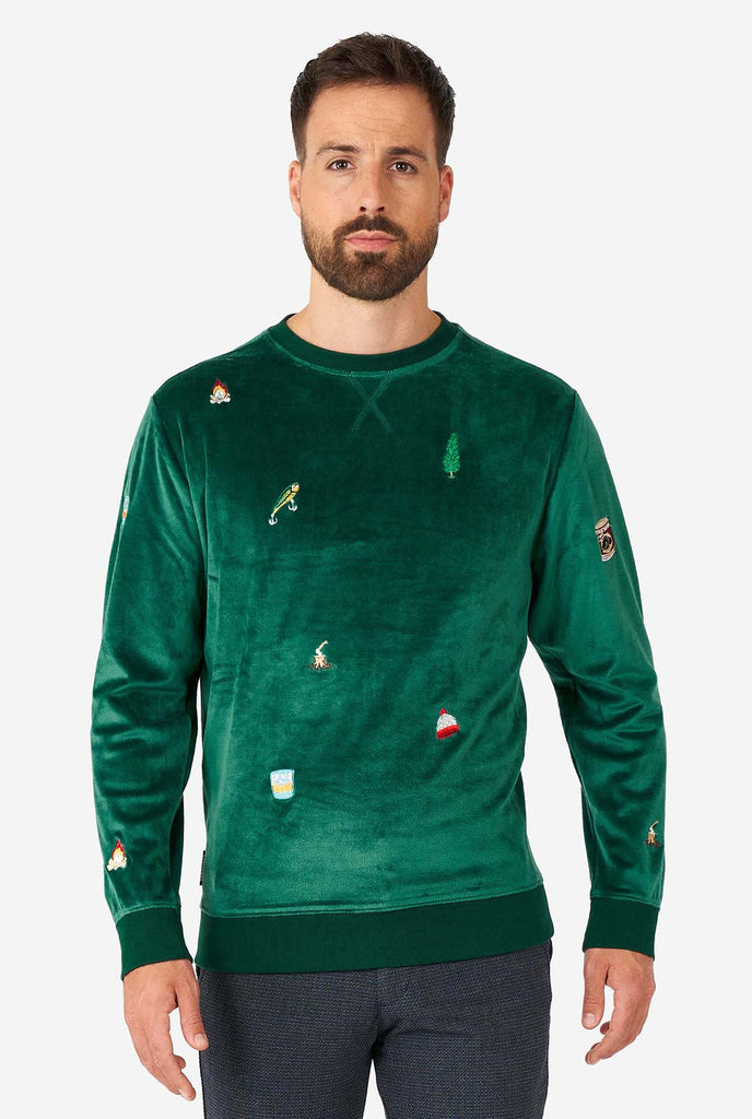 Man wearing velvet green Christmas sweater with Christmas icons