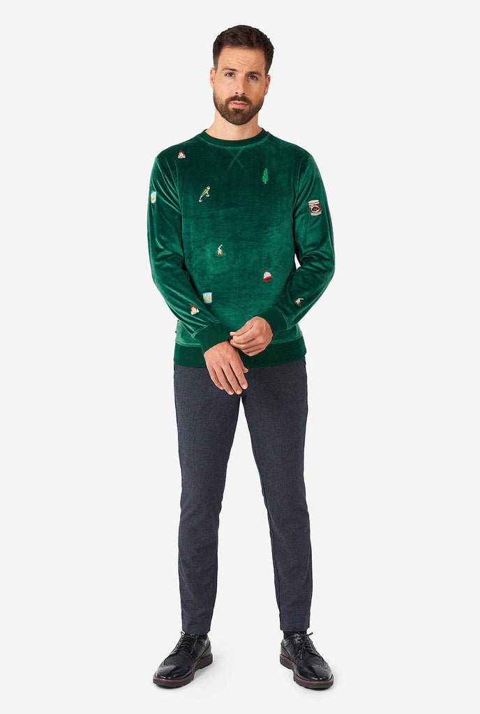 Man wearing velvet green Christmas sweater with Christmas icons