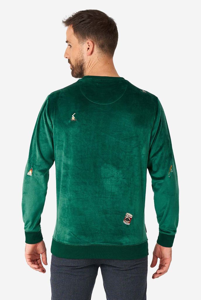 Man wearing velvet green Christmas sweater with Christmas icons