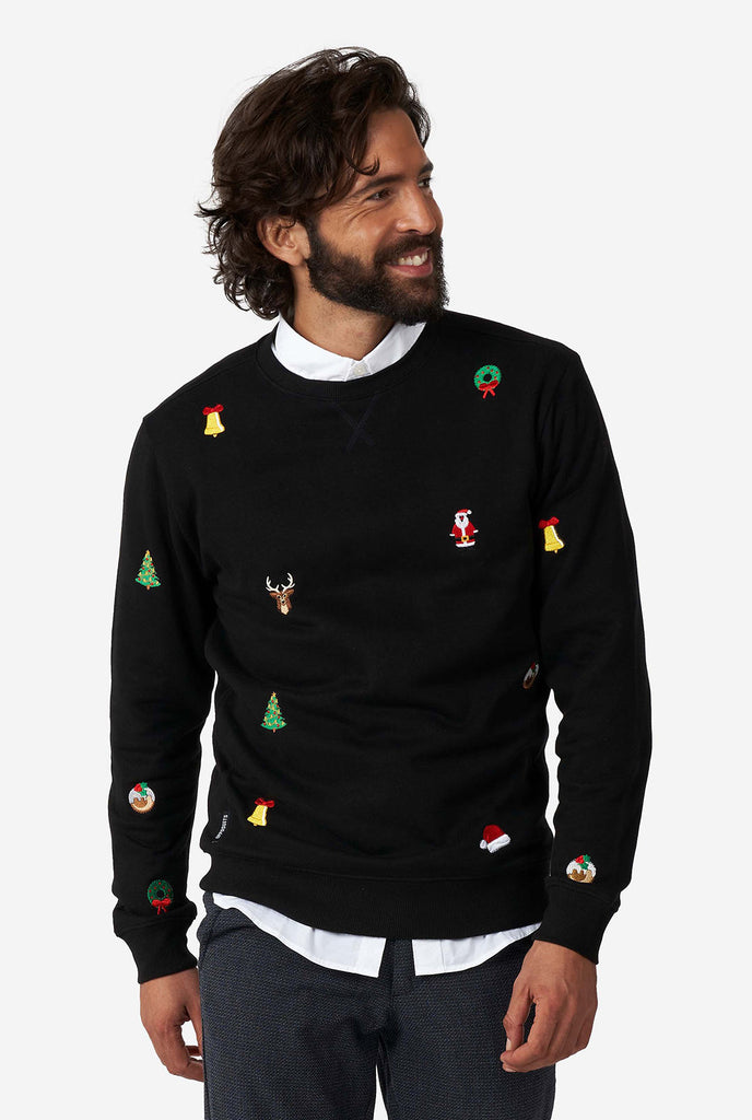 Man wearing black Christmas sweater with Christmas icons