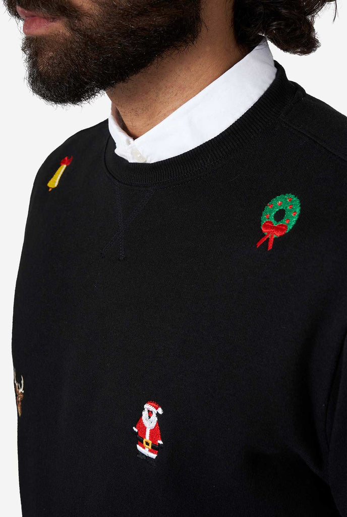 Man wearing black Christmas sweater with Christmas icons