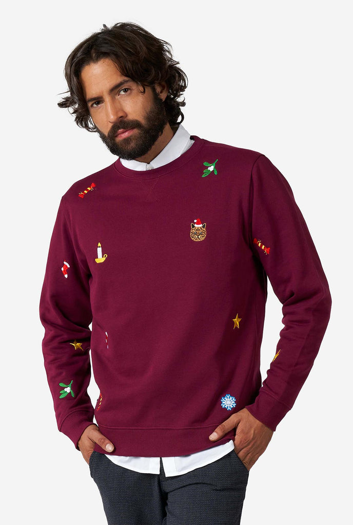 Man wearing burgundy red Christmas sweater with Christmas icons