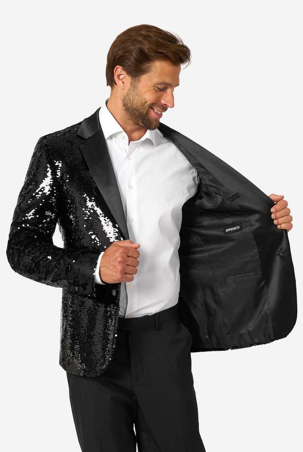 Man wearing a black sequin blazer over a white shirt on a white background