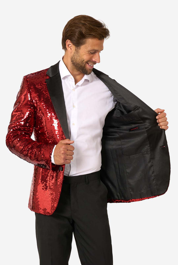 Man holding a red sequin blazer open to reveal a black interior lining.