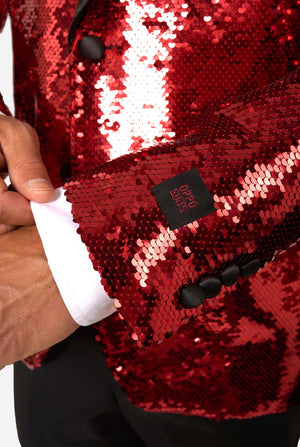 Close-up of a red sequin jacket with a brand label on a white background