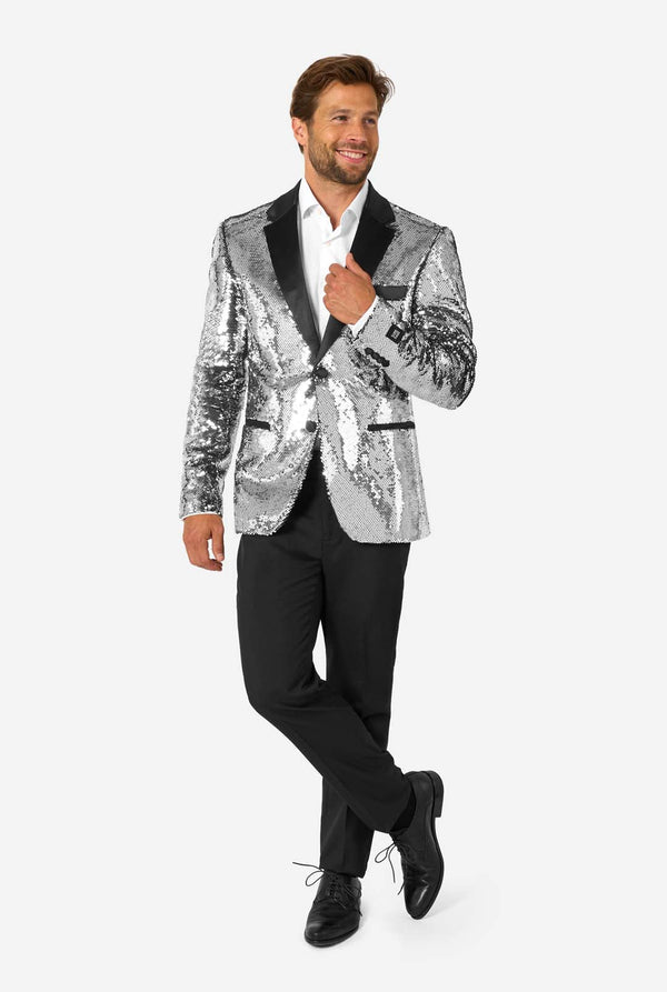 Man wearing a silver sequin blazer over a black shirt and pants on a white background