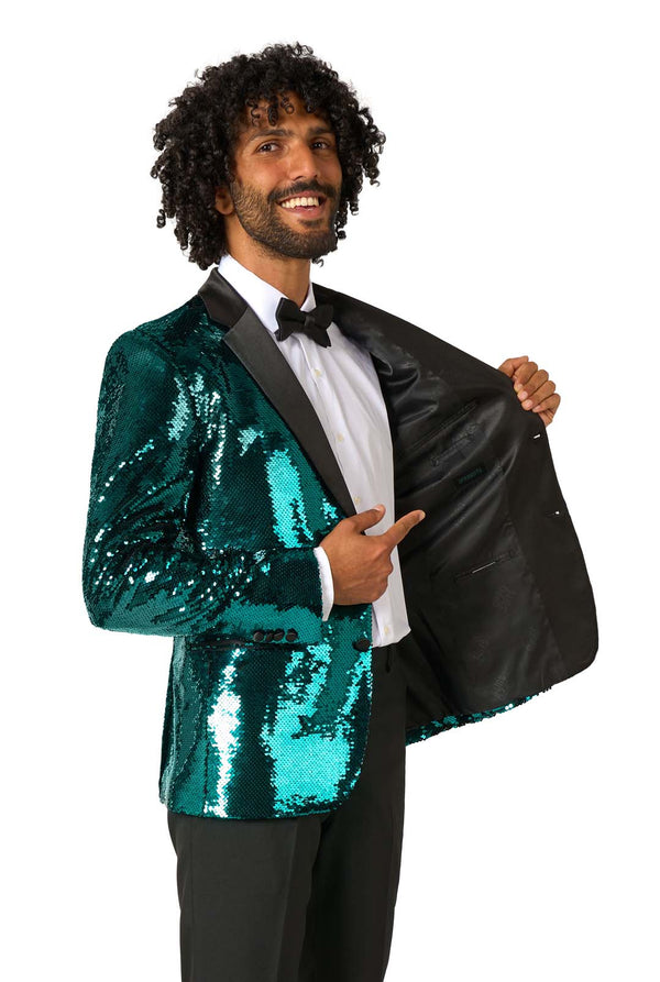 Man wearing a turquoise sequin blazer with a black lapel on a white background