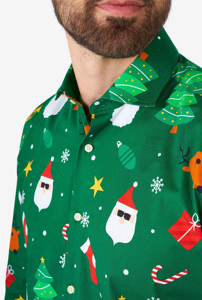 Man wearing green Christmas dress shirt with Christmas icons