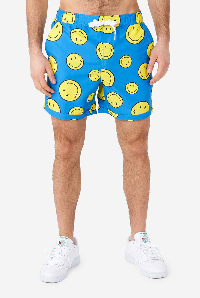 Man wearing blue summer set, consisting of shorts and shirt, with Smiley print