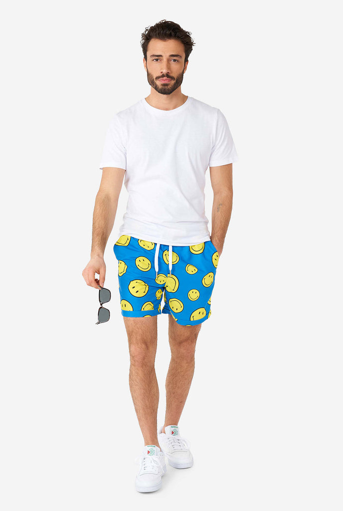 Man wearing blue summer set, consisting of shorts and shirt, with Smiley print