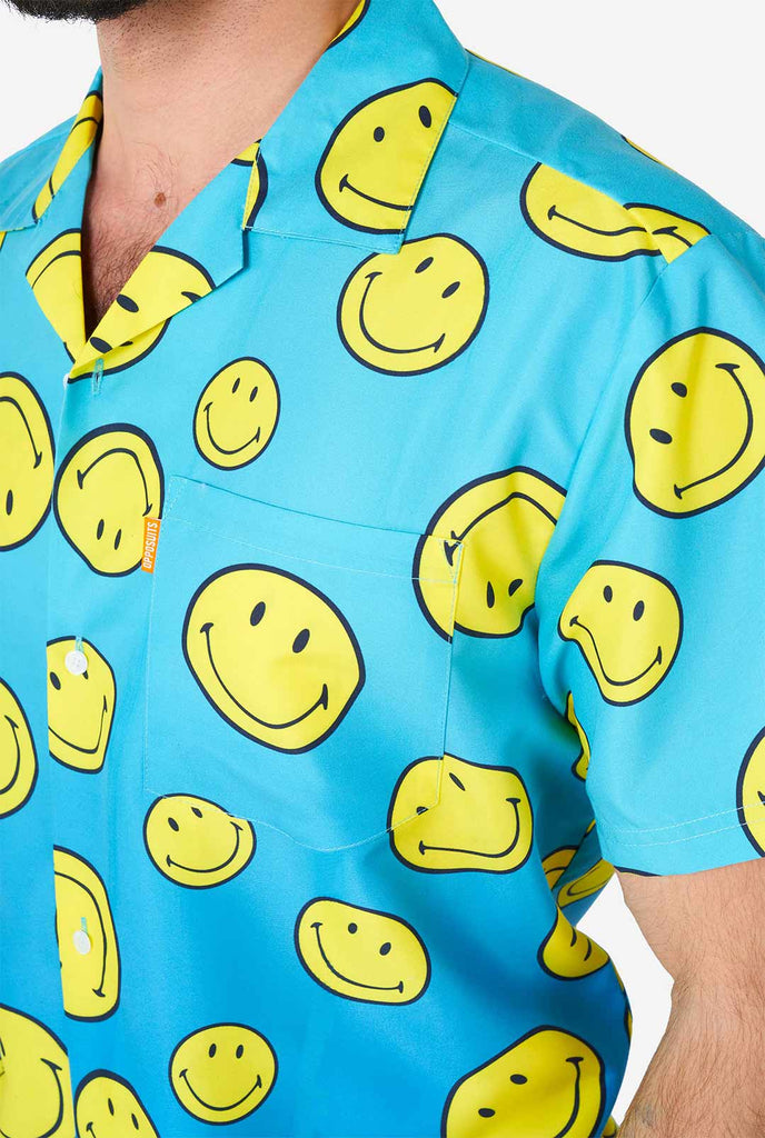 Man wearing blue summer set, consisting of shorts and shirt, with Smiley print