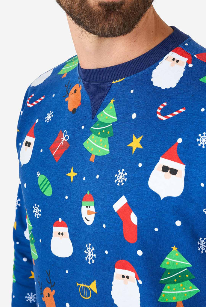 Man wearing blue Christmas sweater with Christmas icons
