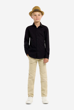 Young boy wearing a black shirt, beige pants, and a brown hat on a white background