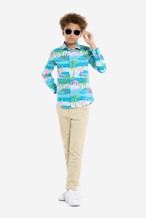 Child wearing a colorful shirt with palm tree design and sunglasses on a white background