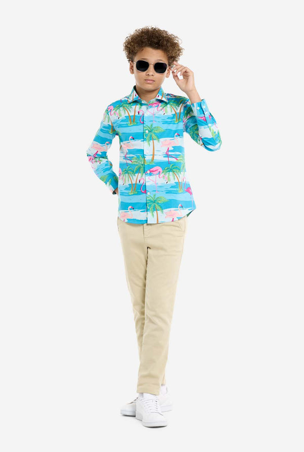 Child wearing a colorful shirt with palm tree design and sunglasses on a white background