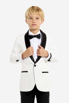 Young boy wearing a white tuxedo with black bow tie and pants on a white background