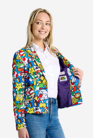 Woman wearing all-over print Super Mario blazer with iconic Super Mario characters. The base is light blue, but there is also yellow, red and white.