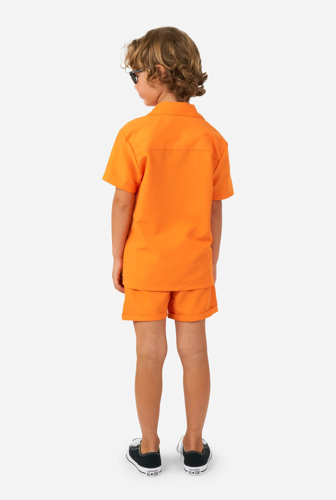 Boy wearing orange summer set, consisting of shorts and shirt, view from the back