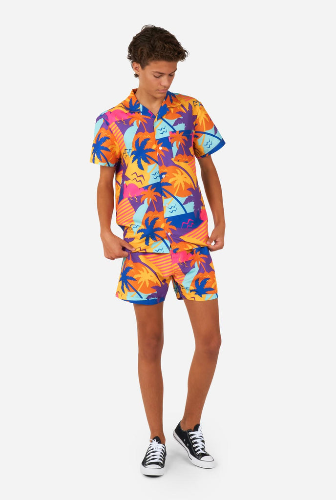 Teen wearing colorful palm summer set, consisting of shirt and short.